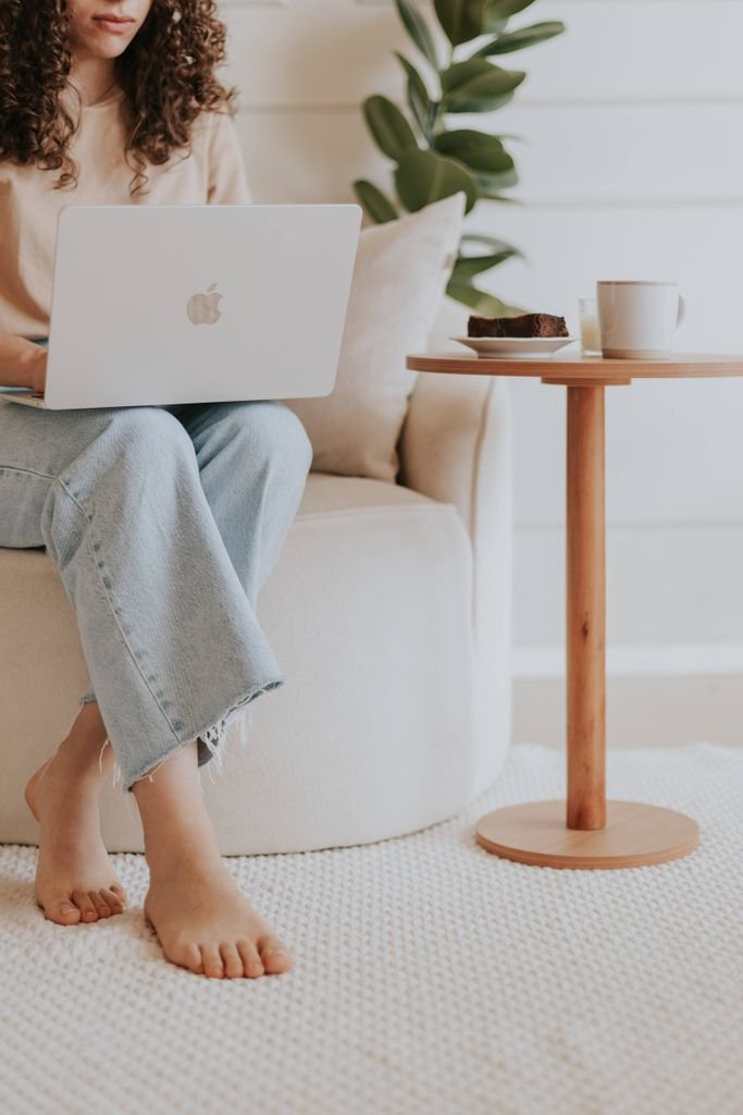 Comfortable home office setting with laptop and coffee cup on a small table.