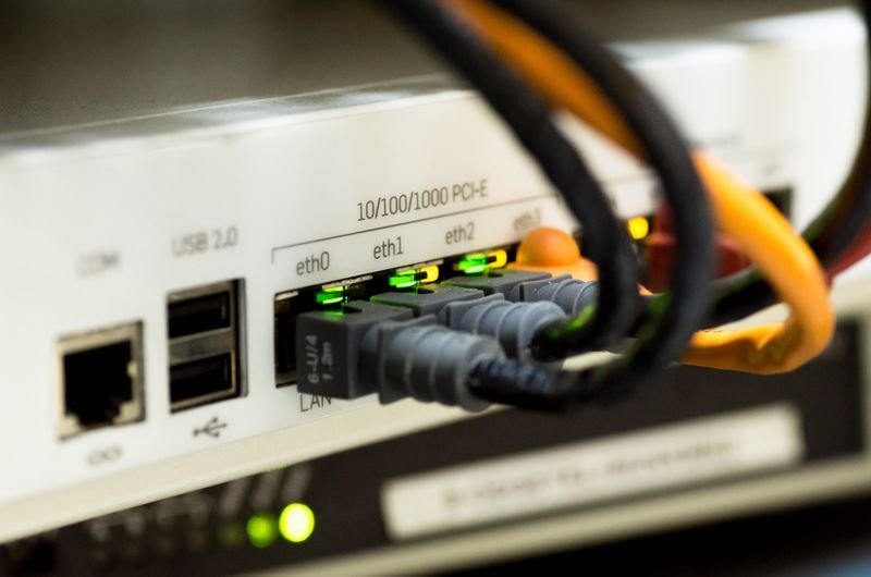Detailed close-up of ethernet cables and network connections on a router, showcasing modern technology.